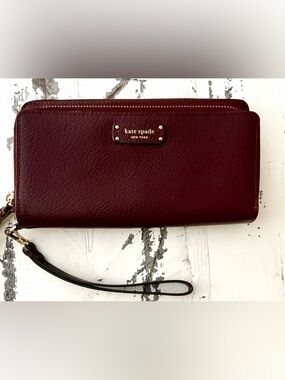 kate spade burgundy pebbled leather wristlet wallet with gold logo